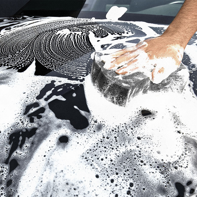 Auton pesu käsin. Shampoo maalipinnalla.
